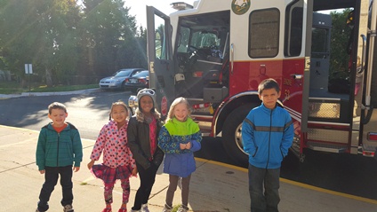 Five students stand close to the fire truck.
