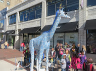 The students take a good look at a giraffe sculpture. 