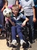 A student, happily holding a soccer ball.
